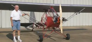 man posing near red plane